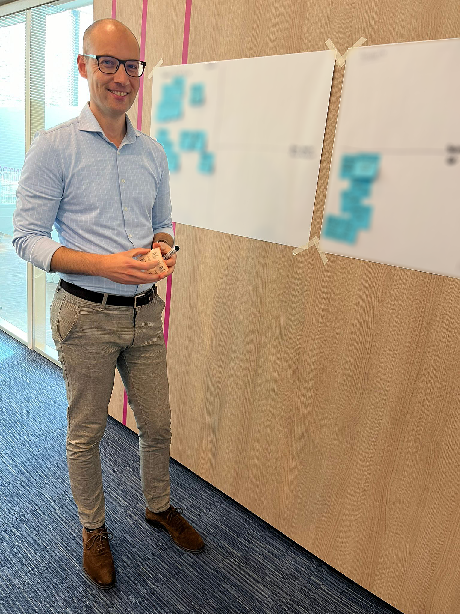 Michiel staat lachend voor een wand met flipoverpapier