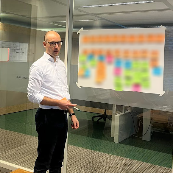 Michiel Kox faciliteert een propositiesessie aan de post-it muur